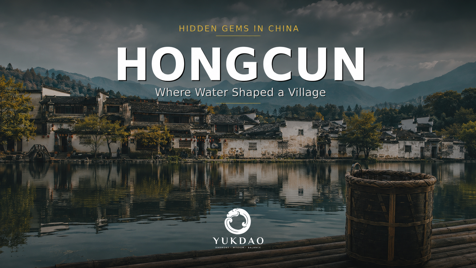 Hongcun's white Huizhou houses and dark tiled roofs reflected in calm water beneath misty mountains in Anhui, China.