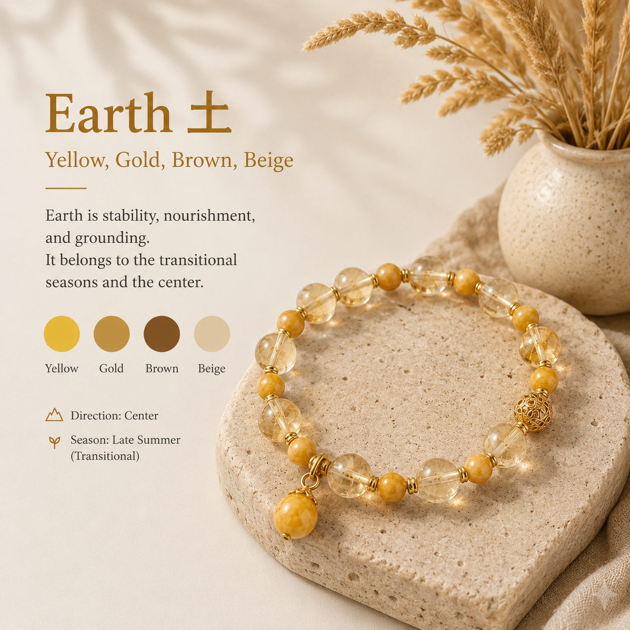 Earth element palette — a citrine and honey-jade bracelet on a warm limestone slab beside a stoneware vase of dried wheat.