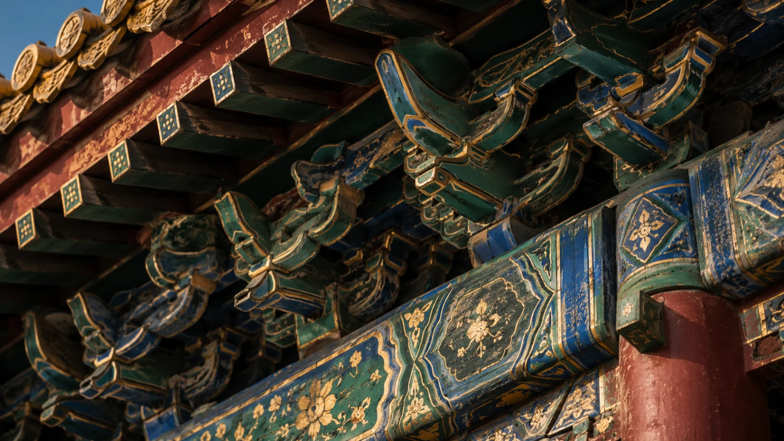 Close view of blue-green painted dougong and traditional timber craftsmanship beneath Forbidden City palace eaves