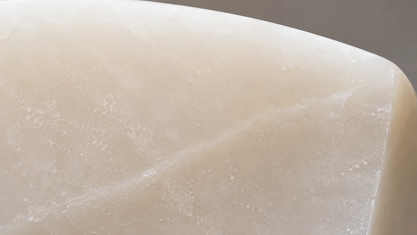 Macro view of a 藕粉玉 jade surface showing a translucent water line running through the stone.